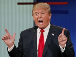 US President Donald J Trump wrapped in Blue suit with red tie, shouting on media persons