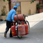 घरेलू गैस सिलेंडर के दाम बढ़े, लखनऊ में कीमत 979.50 Delivery Boy carrying gas cylinders by bicycle.