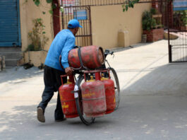 Delivery Boy carrying gas cylinders by bicycle.