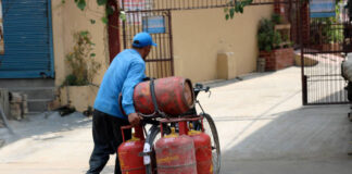 Delivery Boy carrying gas cylinders by bicycle.