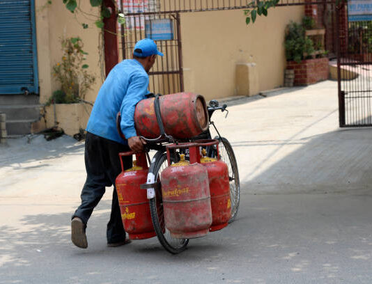 घरेलू गैस सिलेंडर के दाम बढ़े, लखनऊ में कीमत 979.50 Delivery Boy carrying gas cylinders by bicycle.